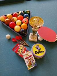 Billardkugeln, Tischtenniskellen, Kartenspiel, Pokal zusammengelegt auf einem Billardtisch
