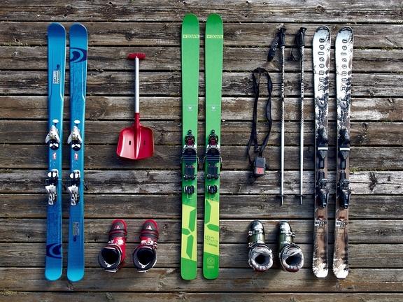 Skier, Schneeschippe, Skistöcke und Ski schuhe stehen auf einem Holzboden bereit